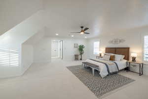 Carpeted bedroom featuring ceiling fan