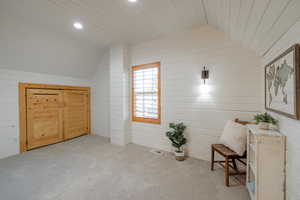 Living area with lofted ceiling and wood walls