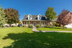 Cape cod-style house with covered porch and a front lawn