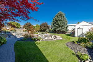 View of yard featuring a storage unit and a patio area