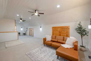 Living room featuring ceiling fan, carpet flooring, and wooden walls