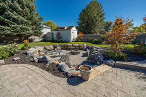 View of patio / terrace featuring an outdoor fire pit and a storage shed