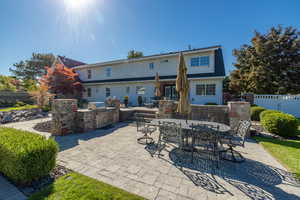 Back of house with an outdoor kitchen and a patio area