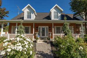 Cape cod house featuring a porch