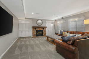 Carpeted living room featuring crown molding and a fireplace