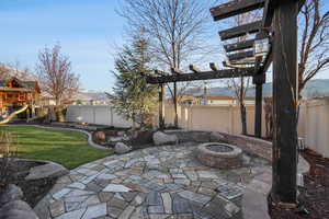 View of patio featuring a playground, a mountain view, and a fire pit