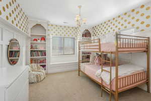 Bedroom featuring light carpet and a notable chandelier