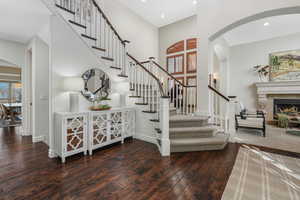 Staircase with plenty of natural light, a high ceiling, and hardwood / wood-style flooring