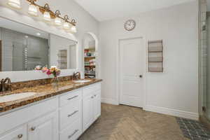 Bathroom featuring vanity, parquet floors, and walk in shower