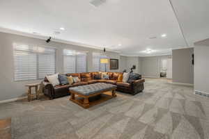 Living room with light colored carpet and ornamental molding