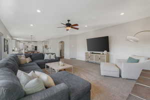 Carpeted living room featuring ceiling fan