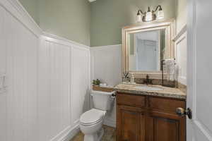 Bathroom with toilet, vanity, and tile patterned flooring