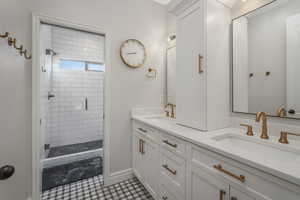 Bathroom with walk in shower, vanity, and tile patterned floors