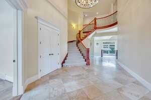 Travertine tile entry  opens to beautiful staircase