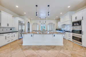 Classic white kitchen with double ovens and granite countertops