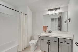 Full bathroom with toilet, shower / tub combo, vanity, and tile patterned floors