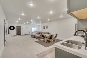 Interior space featuring sink, light carpet, and gray cabinets