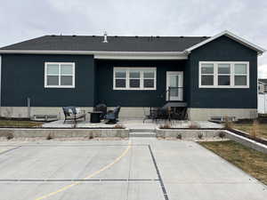 Rear view of property featuring a patio area and an outdoor fire pit