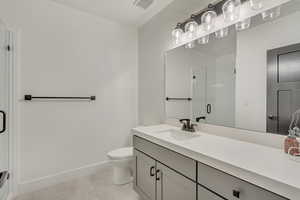 Bathroom featuring toilet, an enclosed shower, vanity, and tile patterned floors