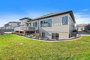 Back of house featuring a deck and a yard