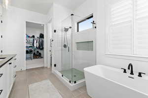 Bathroom with vanity, tile patterned floors, and plus walk in shower