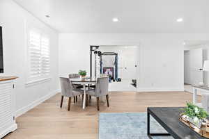 Dining room with a textured ceiling and light hardwood / wood-style flooring