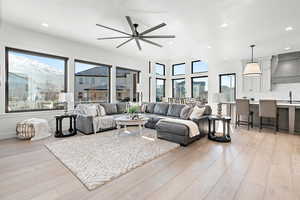 Living room with light wood-type flooring, ceiling fan, and sink