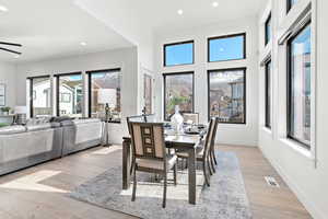 Dining space with ceiling fan, a wealth of natural light, and light hardwood / wood-style floors