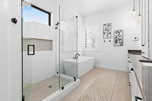 Bathroom featuring plenty of natural light, shower with separate bathtub, vanity, and tile patterned flooring