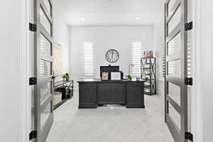 Carpeted home office featuring a healthy amount of sunlight and french doors