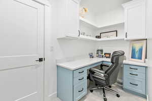 Carpeted office with built in desk in basement