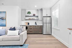 Kitchen featuring stainless steel fridge, light hardwood / wood-style flooring, and wine cooler