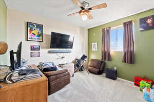 Carpeted room featuring a textured ceiling and ceiling fan