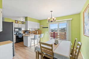 Dining space featuring an inviting chandelier, light hardwood / wood-style flooring, and sink