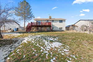 Back of property with a lawn and a deck