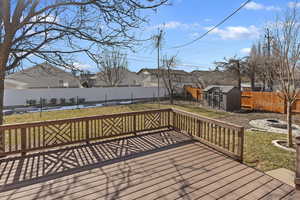 Deck featuring a shed, a yard, and a fire pit