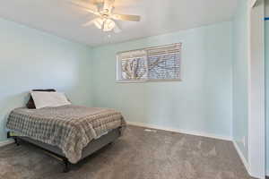 Carpeted bedroom featuring ceiling fan