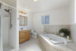 Full bathroom with toilet, tile patterned flooring, separate shower and tub, and vanity