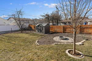 View of yard featuring an outdoor fire pit and a storage unit