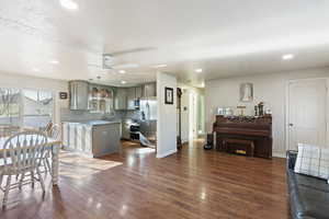 Kitchen with pendant lighting, appliances with stainless steel finishes, a center island, decorative backsplash, and ceiling fan