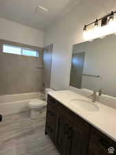 Full bathroom featuring toilet, tiled shower / bath, and vanity