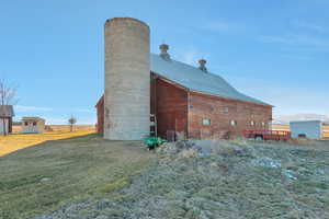 View of side of property with a lawn and an outdoor structure