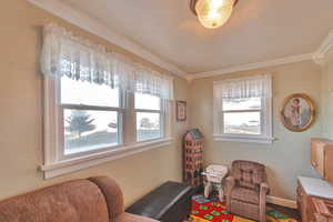 Living area with plenty of natural light and crown molding