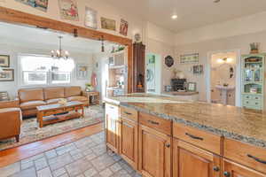 Kitchen featuring light stone counters, pendant lighting, a notable chandelier, and washer / clothes dryer