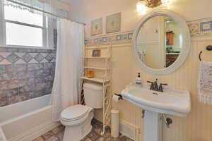 Bathroom featuring toilet and shower / bath combo with shower curtain