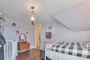 Bedroom featuring dark hardwood / wood-style floors and vaulted ceiling