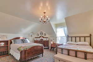 Bedroom with lofted ceiling and a chandelier