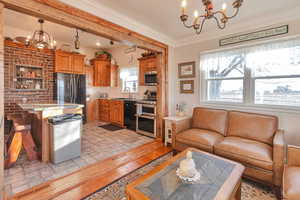 Living room with sink, crown molding, a chandelier, and light hardwood / wood-style floors