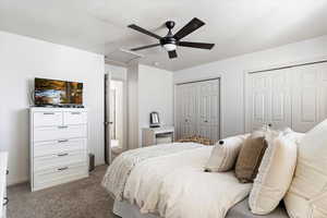 Bedroom with ceiling fan, carpet floors, and two closets