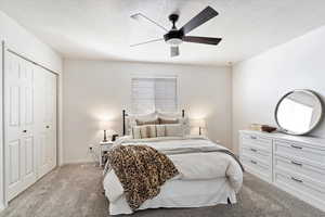 Bedroom featuring ceiling fan, light colored carpet, and a closet